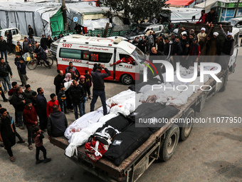 Palestinians are transporting the bodies of their relatives, who were killed in an overnight Israeli strike on the Nuseirat refugee camp, du...