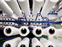 A worker is producing textile foreign trade products on a workshop production line at a spandex company workshop in the Lianyungang Economic...