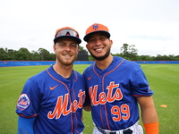 Drake Osborn #13 and Ronald Hernandez #99, minor league catchers for the New York Mets, are posing for a photo during spring training workou...