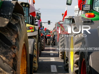 Polish farmers and their supporters park their tractors in a column to block public roads, they carry Polish flags and banners during a prot...