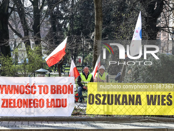 Polish farmers and their supporters hold Polish flags and banners during a protest in front of regional administration office in the centre...