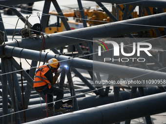 Construction workers are assembling steel structure roof trusses at the east station of Lushan Station of the Anjiu Section of the Beijing-H...