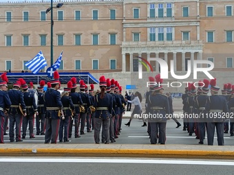 School students are marching through central Athens, past the Hellenic Parliament in Syntagma, dressed in school uniforms and traditional co...