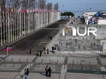 People are walking along one of the walkways in Das Nacoes Park in the Oriente district, in Lisbon, Portugal, on March 13, 2024. (