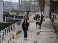 Several people are walking near the banks of the Tejo River in the Oriente district in Lisbon, Portugal, on March 13, 2024. (