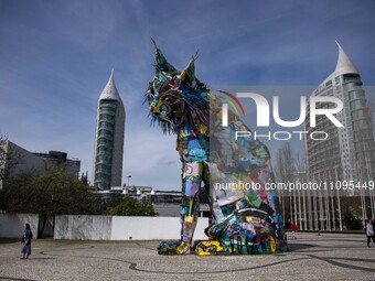 Several people are walking near a statue representing an Iberian lynx in the vicinity of Das Nacoes Park, located in the eastern district of...