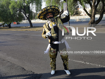 A person dressed as a charro and wearing a Chinelo mask is participating in the Comparsa Faisanes as part of the closing of the annual Santa...