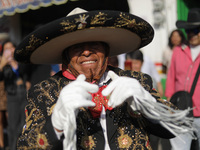 A person dressed in a traditional Charro suit is taking part in the Comparsa Faisanes as part of the closing of the Annual Santa Martha Acat...