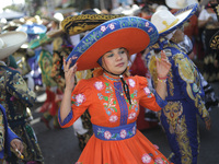 A woman dressed in a traditional Charro suit is participating in the Comparsa Faisanes as part of the closing of the Annual Santa Martha Aca...