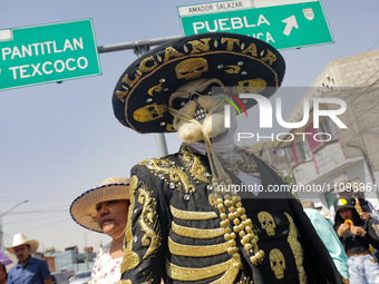 A person dressed as a charro and wearing a mask is participating in the Comparsa Faisanes as part of the closing of the annual Santa Martha...