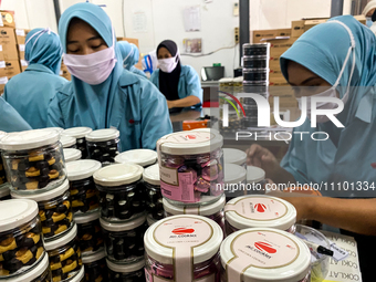 Employees are putting cookies into jars at the J&C Cookies factory in Bandung, Indonesia, on March 27, 2024. The cookie manufacturer, J&C Co...