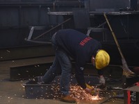 A worker is operating a self-developed water surface cleaning long-arm environmental protection ship at a shipping company's plant in Hangzh...