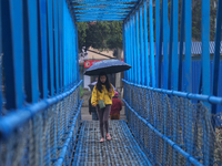 Locals in Kathmandu are taking shelter from the rain as they rush to their destinations after a climatic effect induced rainfall on March 28...