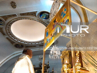 Father Bernardo Lanuza, OFM, is genuflecting after he has placed the wrapped consecrated Eucharist hosts inside the Altar of Repose for the...