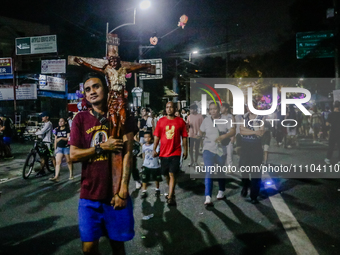 Mark, 35, is carrying a cross while walking towards the International Shrine of Our Lady of Peace and Good Voyage in Antipolo City, Philippi...