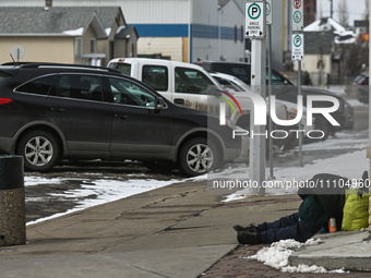 EDMONTON, CANADA - MARCH 28:
A homeless person sleeps on the pavement in downtown Edmonton area, on March 28, 2024, in Edmonton, Alberta, Ca...