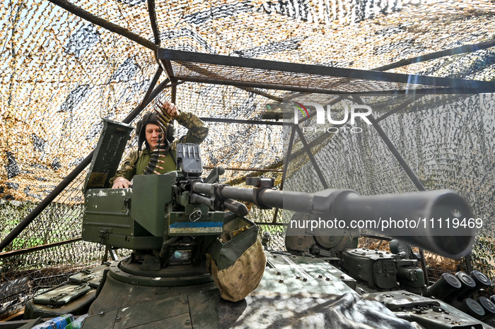 A serviceman from the 1st Tank Brigade of the Ukrainian Ground Forces is holding an ammunition belt on a tank in Ukraine, on March 31, 2024....