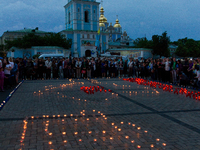 People create the outline of the Crimean peninsula with lighted candles and the Crimean Tatars symbol 