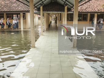 Number of student walking in flooded classroom in high school SMKN 1, Village Kramat Sari, Pekalongan, Central Java, Indonesia, on April 11,...