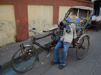 An indian rickshaw puller lays down in his trolly as he faints due to heat stroke , during a hot day in Allahabad on April 20,2016. weeks of...