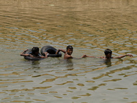 Village children floats in the water of an irrigation canal by the help of air filled tube as they are playing in the water to beat the heat...
