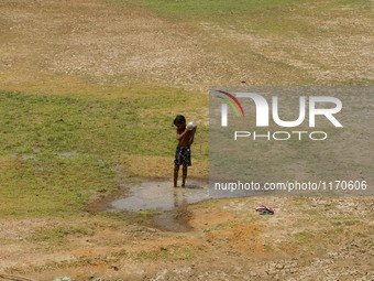 A village boy baths in the remaining water of a dried pond to beat the heat in today’s hot afternoon outskirts of the eastern Indian city Bh...
