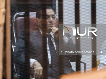 Egypt's deposed president Hosni Mubarak waves from behind the accused cage during his trial on May 21, 2014 in Cairo. An Egyptian court sent...