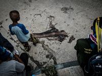 A young boy looks over the blood covered spot where 3 people were shot dead and a hand grenade exploded in Bangkok. Thailand's army chief an...