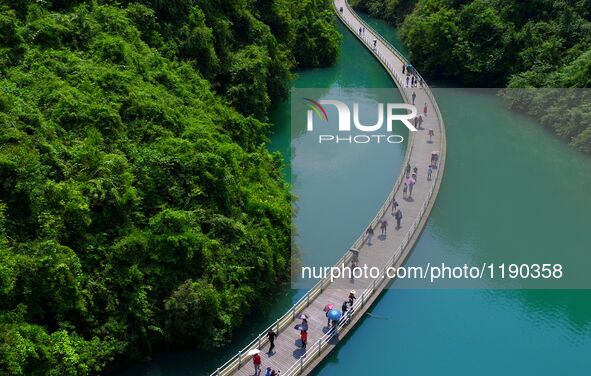 Tourists walk on a 500-meter-long plank road built over the river in Xuan'en County, central China's Hubei Province, May 1, 2016.