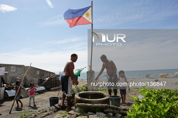 Tacloban, Philippines - Men take turns in fetching water in Tacloban City on June 11, 2014. June 12 marks the Philippines' 116th Independenc...