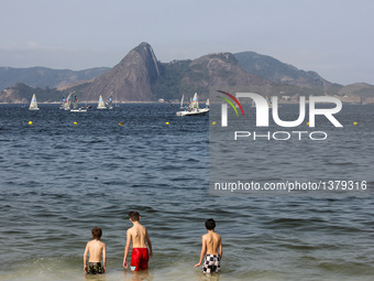 Finn sailing race at the 2016 Summer Olympics Rio in Rio de Janeiro, Brazil. Brazilians and foreigners enjoy the Flamengo beach, which is ba...