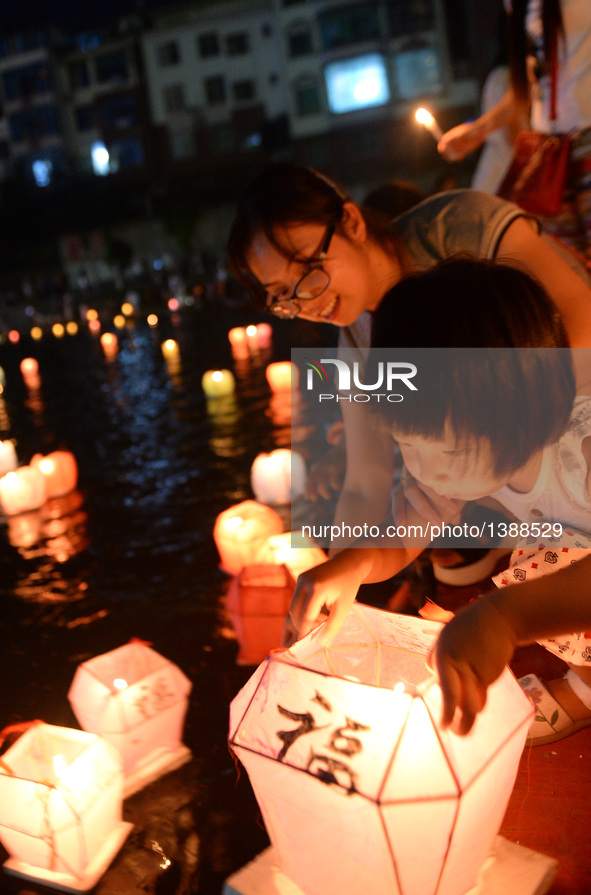 A girl puts a lantern into the river during a traditional lantern fair in Ziyuan County, south China's Guangxi Zhuang Autonomous Region, Aug...