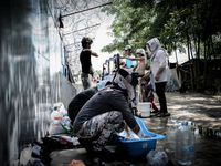 Refugees women while doing laundry at a makeshift refugee camp on the Serbian side of the border with Hungary near the town of Horgos on Aug...