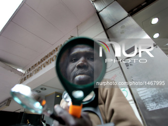 African immigrant selling magnifying glasses, Athens, Greece, Feb 2, 2011 (Photo by Giorgos Georgiou/NurPhoto)