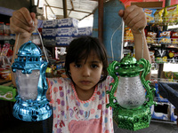 A Palestinian girl holds traditional Ramadan lanterns at a market in Rafah in the southern Gaza Strip on June 28, 2014. Starting on Sunday,...