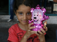 A Palestinian girl holds traditional Ramadan lanterns at a market in Rafah in the southern Gaza Strip on June 28, 2014. Starting on Sunday,...