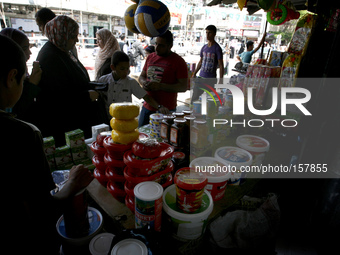 A Palestinians stock up on food in preparation for the Ramadan at a market in Rafah in the southern Gaza Strip on June 28, 2014. Starting on...