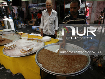 A Palestinians stock up on sweets in preparation for the Ramadan at a market in Rafah in the southern Gaza Strip on June 28, 2014. Starting...