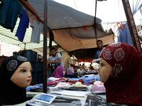 A Palestinian vendor displays a the Islamic hijab at a market in Rafah in the southern Gaza Strip on June 28, 2014. Starting on Sunday, Musl...