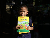 An Indigenous boy hold new textbooks, pose for photograph in Bandarban in Chittagong, South-Eastern Bangladesh on January 1, 2017. Over four...