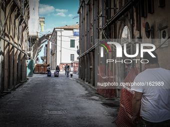 In the background a group of students walking along the historic center of L'Aquila on July 2, 2014, severely damaged after the quake of Apr...