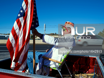 Sitting in the back of his Ford pick-up, Larry Shaak, of Harrisburg, PA., is seen dressed up as Trumpman, as he waves to passers-by on their...