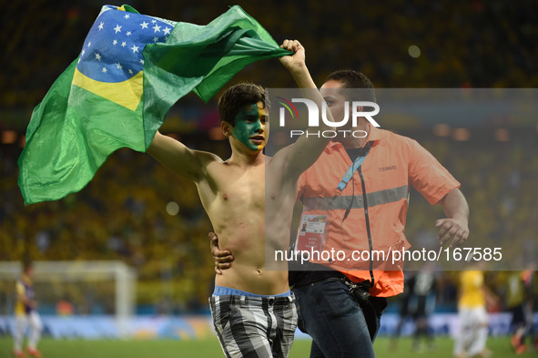 (140704) -- FORTALEZA, July 4, 2014 () -- A security member drags off a fan who runs into the field after a quarter-finals match between Bra...