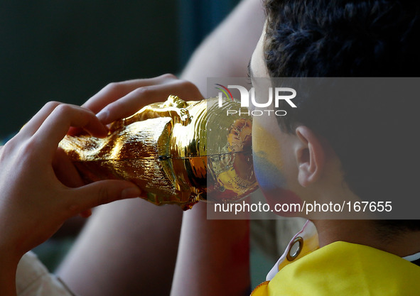 (140704) -- FORTALEZA, July 4, 2014 () -- A Colombia's fan kisses a replica of the FIFA World Cup Trophy before a quarter-finals match betwe...