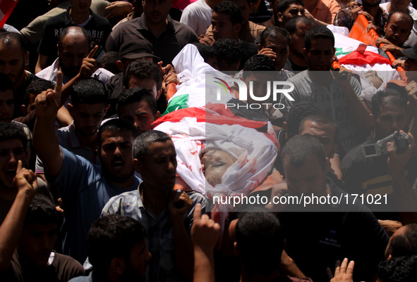 Palestinians carry the bodies of members of the Hamad family during funeral in town of Beit Hanoun in the northern Gaza Strip on July 9, 201...