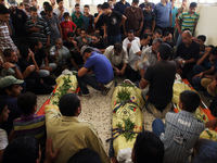 Relatives and friends of the al-Kaware family mourn over one of the 7 members of the family during their funeral in Khan Yunis, in the Gaza...