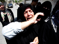 Female members of the al-Kaware family grieve during the funeral for 7 killed members of the family in Khan Yunis, in the Gaza Strip, on Jul...