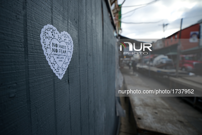 A hart shaped message in support of immigrants s found on the wall of a market stand as several immigrant-owned stores along the landmark It...