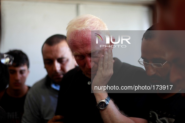 A relative of killed Palestinian doctor Anas Abu al-Kas, 33, mourns over his body during his funeral in the family home in the Jabalia refug...