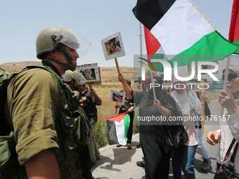 Palestinians hold national flags and pictures of children who were killed in the Israeli attack on the Gaza Strip during a march against the...
